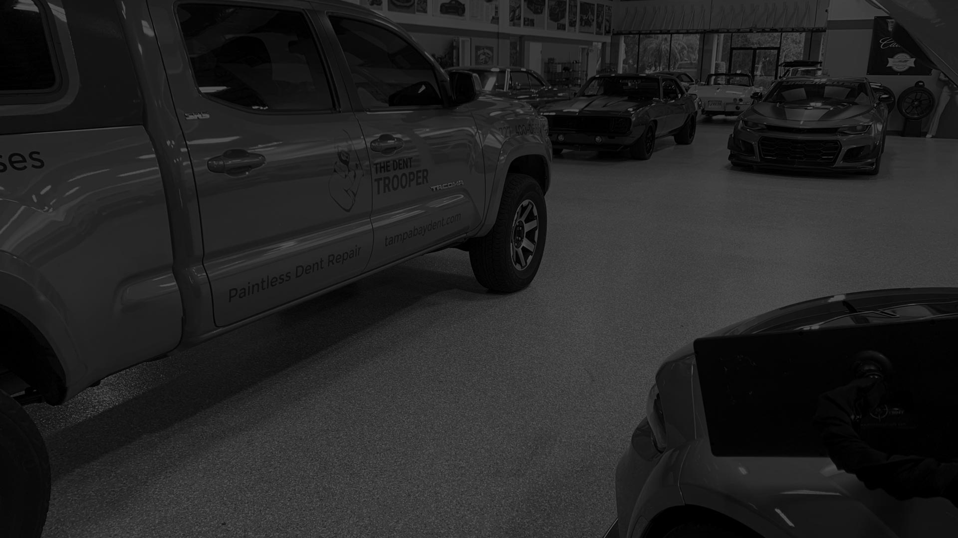 The Dent Trooper mobile paintless dent repair truck parked in a West Central Florida showroom